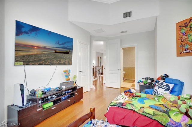 bedroom featuring light hardwood / wood-style floors and ensuite bathroom