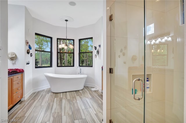 bathroom featuring a notable chandelier, vanity, and independent shower and bath