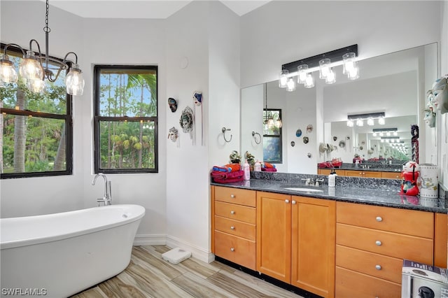 bathroom with a bathtub, vanity, a chandelier, and tile flooring