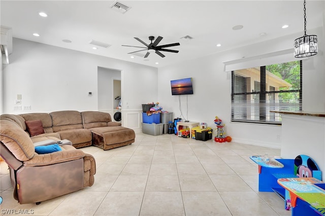 tiled living room with ceiling fan with notable chandelier