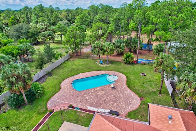 view of pool with a lawn and a trampoline