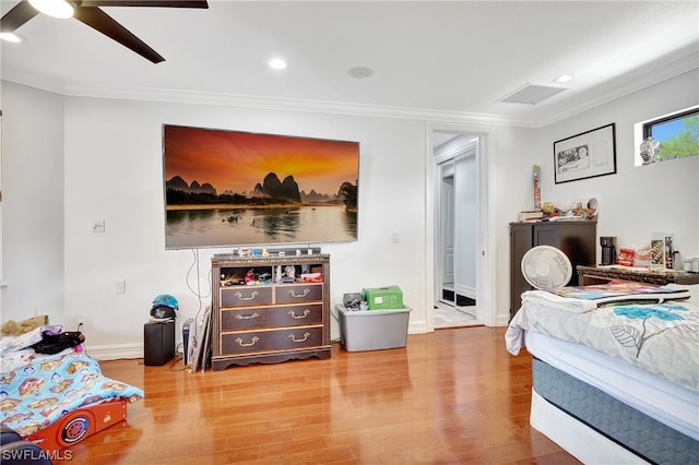 bedroom featuring hardwood / wood-style floors, ornamental molding, and ceiling fan