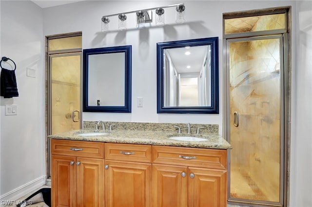 bathroom featuring a shower with door and dual vanity