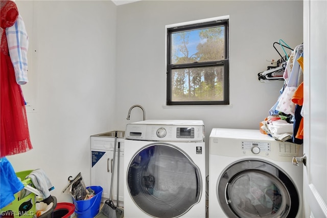 clothes washing area featuring washing machine and clothes dryer and a wealth of natural light