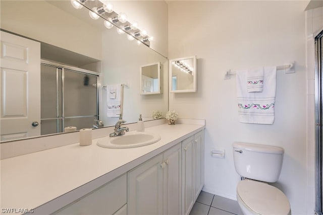 bathroom featuring tile patterned flooring, vanity, an enclosed shower, and toilet