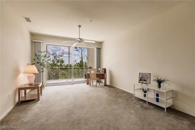 sitting room with ceiling fan and dark carpet