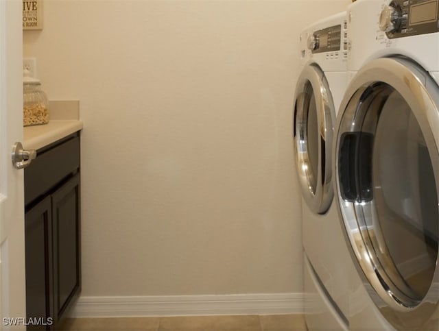 laundry area featuring separate washer and dryer, cabinets, and light tile patterned flooring