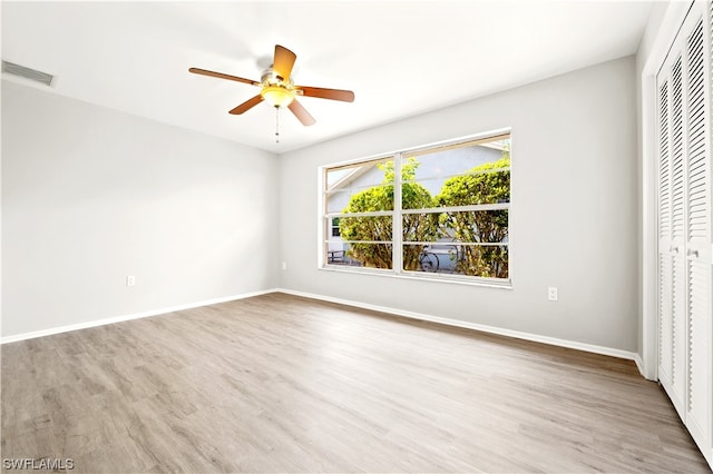 unfurnished bedroom featuring a closet, light hardwood / wood-style floors, and ceiling fan