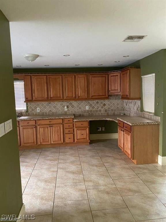 kitchen with sink, backsplash, and light tile flooring