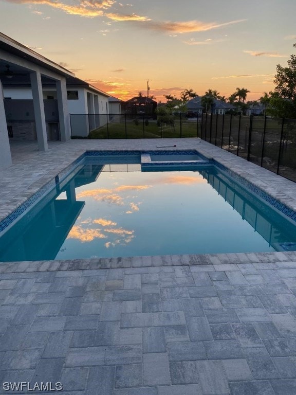 pool at dusk with a patio