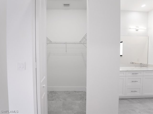 walk in closet featuring light tile floors