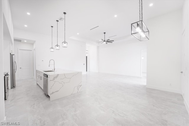 kitchen with decorative light fixtures, light stone countertops, ceiling fan, a center island with sink, and appliances with stainless steel finishes