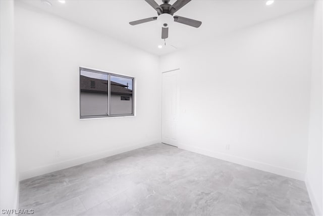 tiled spare room with ceiling fan