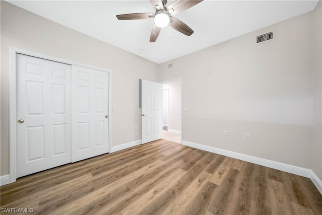 unfurnished bedroom featuring a closet, light hardwood / wood-style floors, and ceiling fan