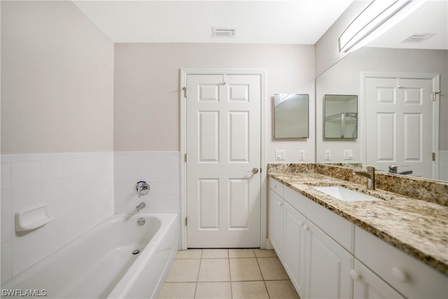 bathroom with a bath, large vanity, and tile flooring