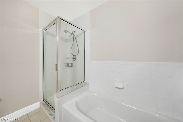 bathroom featuring shower with separate bathtub and tile flooring