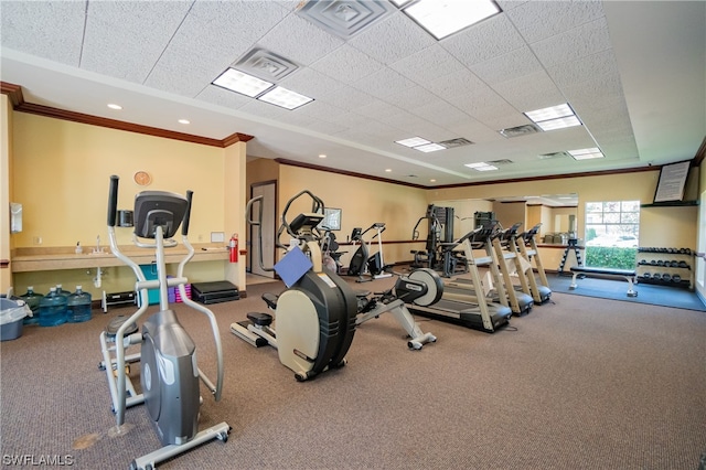 exercise room featuring carpet, ornamental molding, and a paneled ceiling