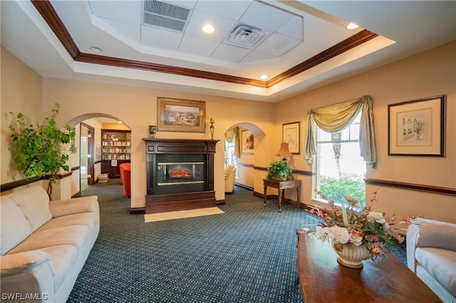 living room with a raised ceiling, ornamental molding, coffered ceiling, and dark colored carpet