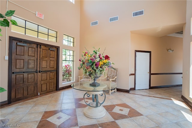 foyer featuring light tile floors and a towering ceiling