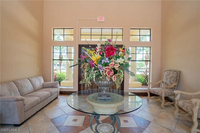 living room featuring light tile floors and a high ceiling