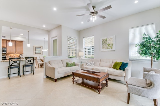 living room with ceiling fan, light tile floors, and a wealth of natural light