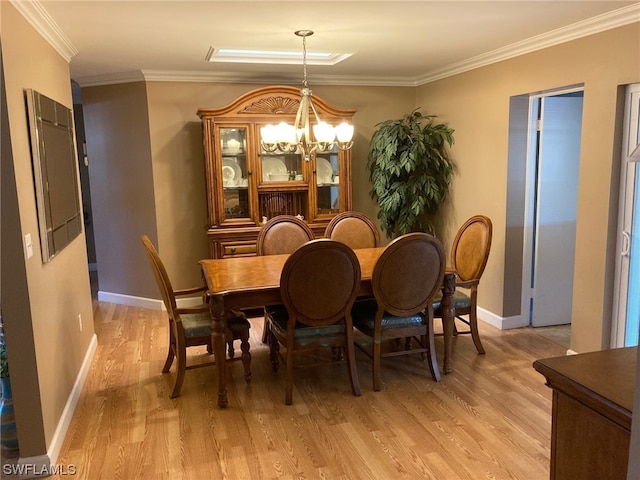 dining area featuring crown molding, a notable chandelier, and light hardwood / wood-style flooring