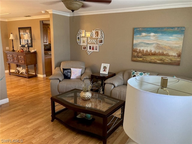 living room with crown molding, light hardwood / wood-style floors, and ceiling fan