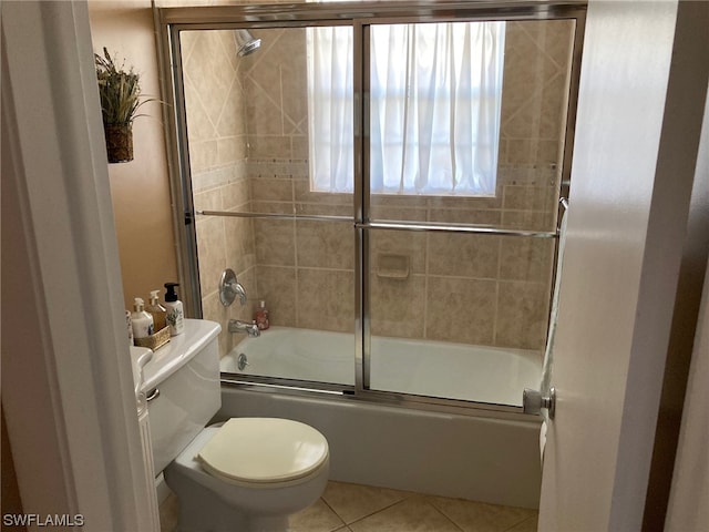 bathroom featuring shower / bath combination with glass door, toilet, and tile floors