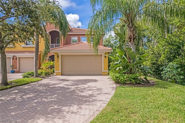 mediterranean / spanish home featuring a front lawn and a garage