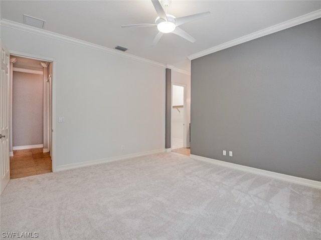 spare room featuring crown molding, light carpet, and ceiling fan