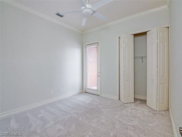 unfurnished bedroom with ornamental molding, light colored carpet, a closet, and ceiling fan