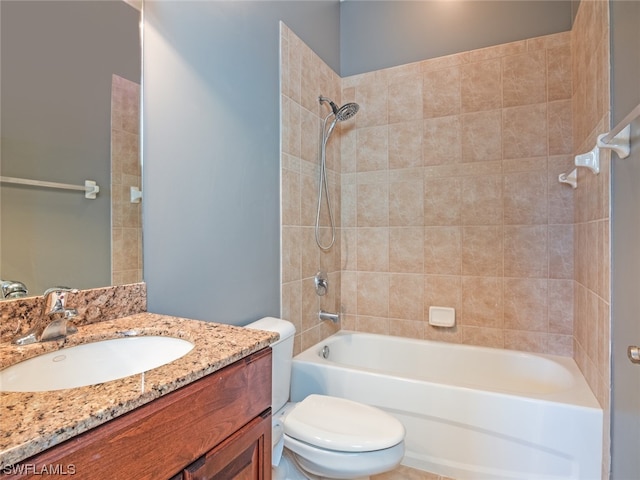 full bathroom featuring vanity, tiled shower / bath combo, and toilet