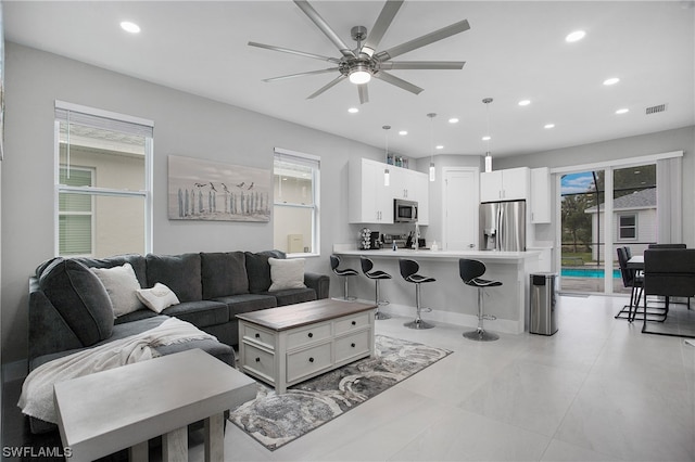 living room with light tile floors and ceiling fan