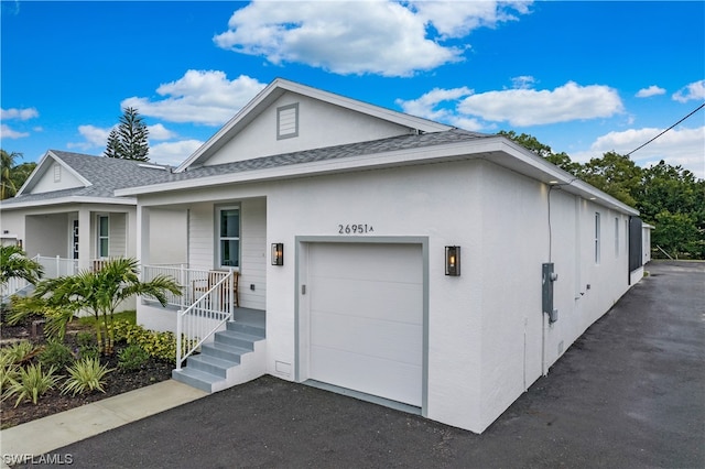 exterior space with covered porch and a garage