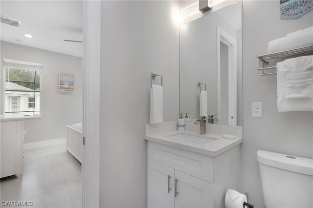 bathroom with toilet, tile flooring, and oversized vanity