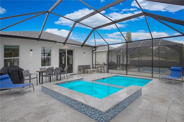 view of pool with a patio, an in ground hot tub, and glass enclosure