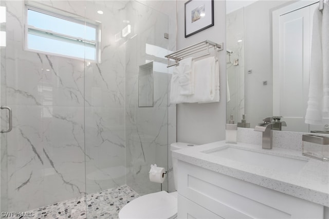 bathroom featuring toilet, large vanity, and walk in shower