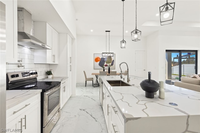 kitchen with wall chimney exhaust hood, stainless steel range with electric stovetop, decorative light fixtures, and sink