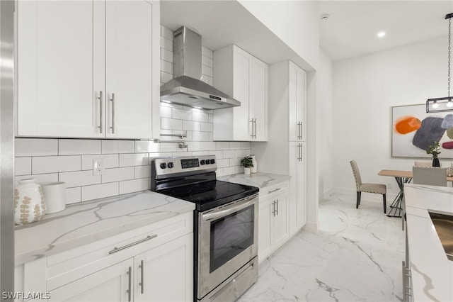 kitchen with wall chimney exhaust hood, stainless steel electric stove, decorative light fixtures, white cabinets, and tasteful backsplash