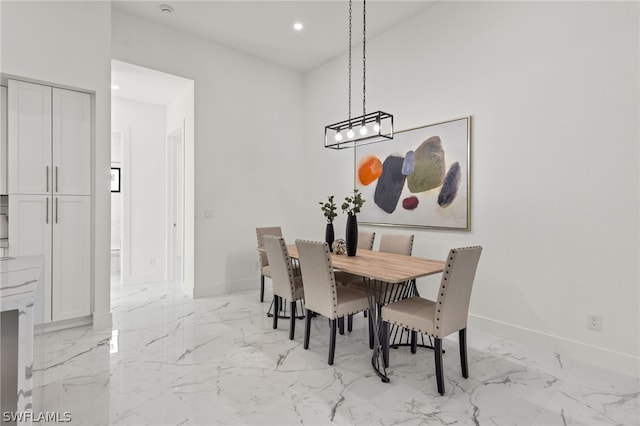 tiled dining room with a towering ceiling and a chandelier