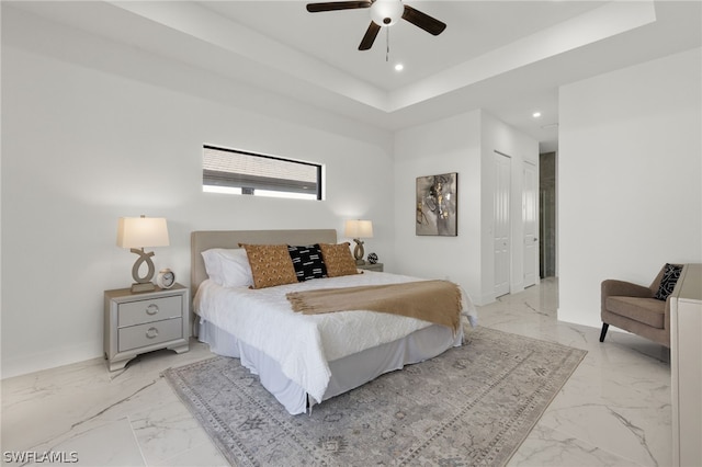 tiled bedroom featuring a closet, ceiling fan, and a raised ceiling