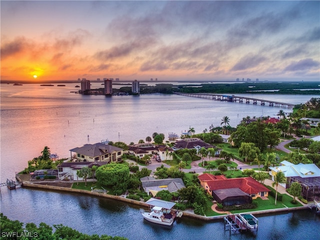 aerial view at dusk featuring a water view