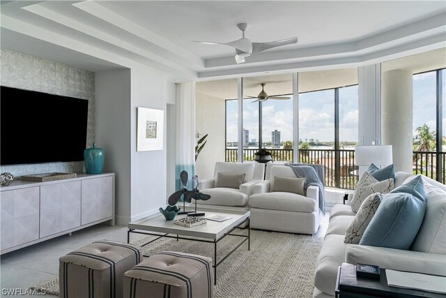 4142 Bay Beach Ln Unit 303, Fort Myers Beach, FL 33931 - living room with floor to ceiling windows, ceiling fan, plenty of natural light, and a raised ceiling