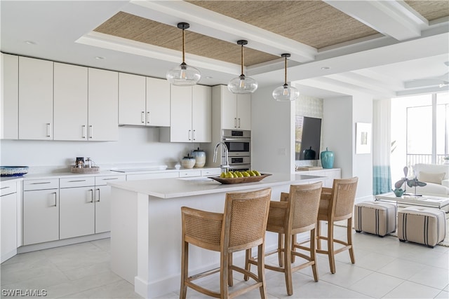 kitchen featuring a breakfast bar, hanging light fixtures, and a tray ceiling