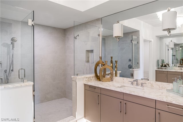 bathroom with a shower with shower door and vanity