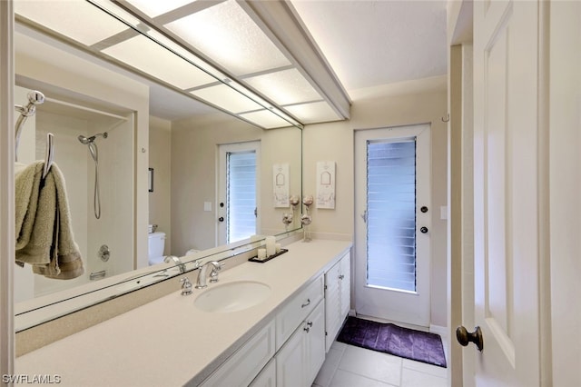 bathroom with tile patterned floors, vanity, toilet, and walk in shower