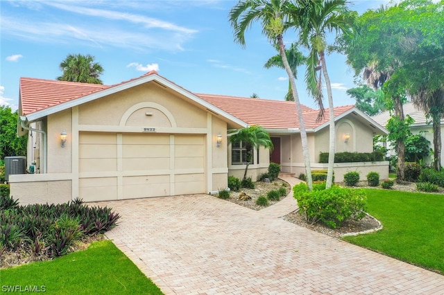 single story home with central AC, a garage, and a front lawn