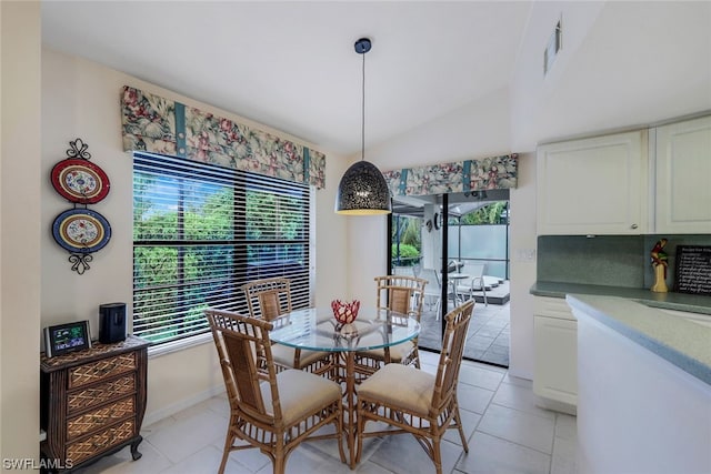 dining area featuring plenty of natural light, light tile patterned flooring, and lofted ceiling