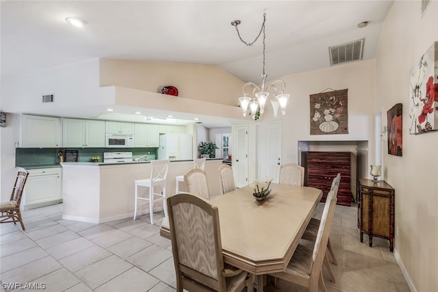 tiled dining area with a notable chandelier and high vaulted ceiling