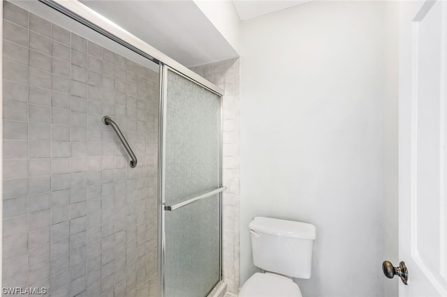 bathroom with an enclosed shower and toilet